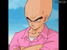 a bald man in a pink shirt with his arms crossed looks angry