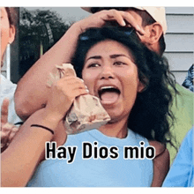 a woman is holding a bag with her mouth open and the words hay dios mio written on it