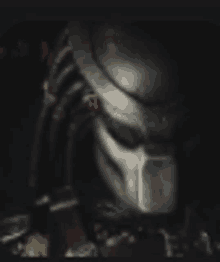 a close up of a predator 's helmet with red eyes