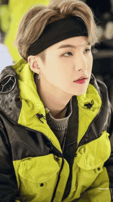 a man wearing a headband and a yellow jacket