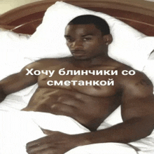 a shirtless man is laying on a bed with a foreign language caption