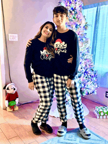 a boy and a girl wearing merry christmas pajamas