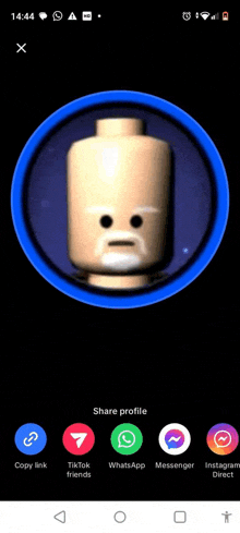 a phone screen shows a lego head in a blue circle with a face on it