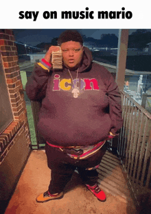 a man in an icon sweatshirt holds a stack of money