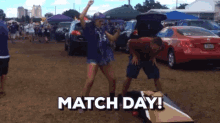 a man and a woman are playing a game of cornhole in a parking lot with the words match day on the bottom