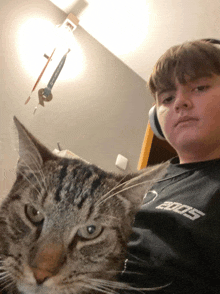 a boy wearing headphones is holding a cat in his lap