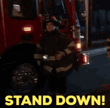 a fireman is standing in front of a fire truck with the words " stand down " written on the bottom