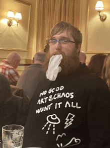 a man with a beard is wearing a sweatshirt that says no good art & chaos want it all