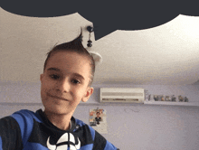 a young boy with a mohawk takes a selfie in a room