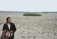 a man in a suit stands in the middle of a desert with the words " pef drought is over " below him