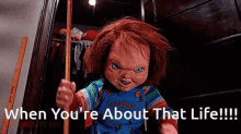 a chucky doll is holding a broom in a closet .