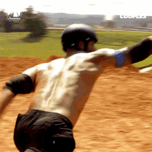 a shirtless man wearing a helmet is riding a skateboard on a dirt road with a paramount network logo in the background