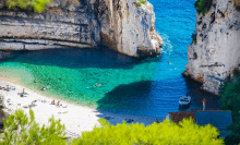 a small boat is docked in the water near a cliff