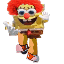 spongebob is dressed as a clown with a red wig and red nose