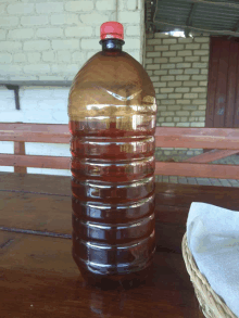 a large plastic bottle with a red cap sits on a table