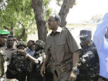 a group of soldiers are gathered around a man in a green shirt