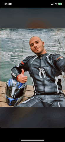 a man giving a thumbs up while holding a helmet