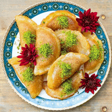 a plate of food with green pistachios and red flowers on top