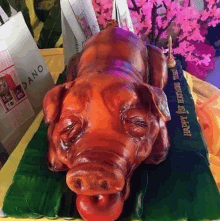 a cake in the shape of a pig on a banana leaf .