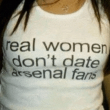 a woman is wearing a white shirt that says real women don 't date arsenal fans