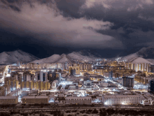 a snowy city with mountains in the background