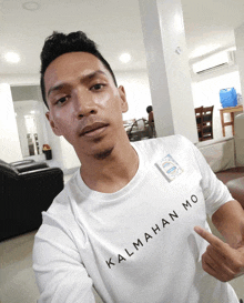 a man wearing a white shirt that says kalmahan mo on it