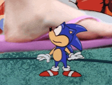 a cartoon of sonic the hedgehog is standing in front of a foot