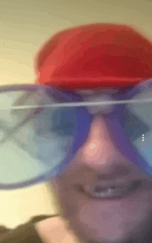 a blurry picture of a person wearing a red hat and blue glasses