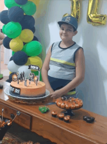 a boy stands in front of a cake that says free fire