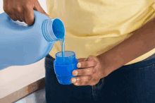 a person pouring a blue liquid into a blue cup