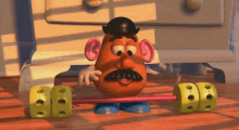 mr potato head is lifting a barbell on a wooden table