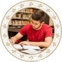 a man in a red shirt sits at a desk in front of a library