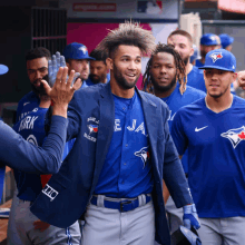 a group of blue jays players are walking in a line