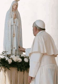 a man in a white robe is standing next to a statue of a woman