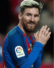 a soccer player wearing a laliga jersey applauds