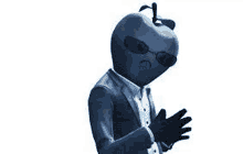 a man in a suit with an apple head is wearing sunglasses and gloves .