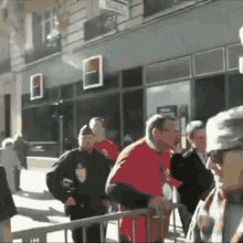 a man in a red shirt is standing in front of a building with a sign that says ' banque populaire '