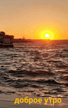 a sunset over a body of water with the words " доброе утро " below it