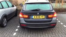 a bmw is parked in a parking lot with a license plate that says 4-khx-91