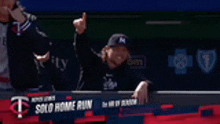 a man giving a thumbs up in front of a solo home run sign