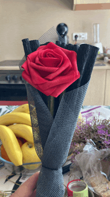 a person is holding a bouquet of flowers with a red rose