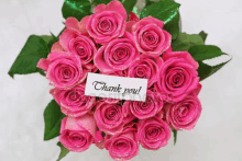 a bouquet of pink roses with a thank you card attached to them .