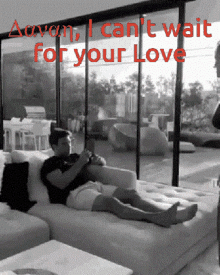 a black and white photo of a man laying on a couch with the words " i can 't wait for your love " above him