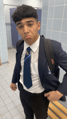 a young man wearing a suit and tie with a badge on his jacket that says ' a '