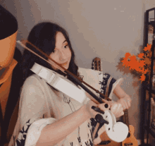 a woman is playing a violin with a bow