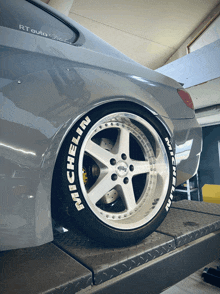 a car with michelin tires is sitting on a lift