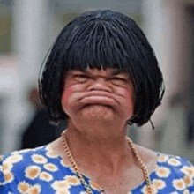 a woman wearing a wig is making a funny face .