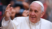 a man in a white robe and hat is smiling and waving