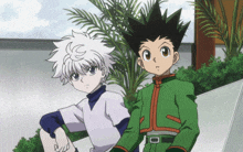 a couple of anime characters sitting next to each other with one of them wearing a green jacket