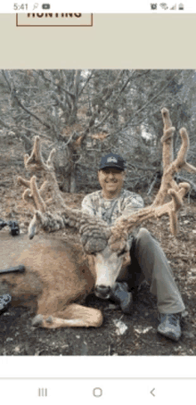 a man is kneeling next to a dead deer